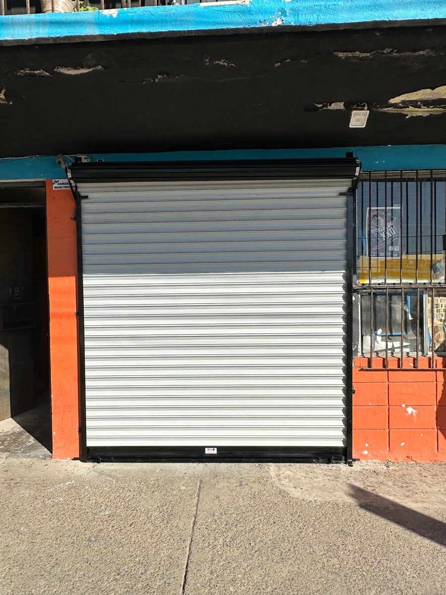 Cortina europeo comercial blanca en local con fachada naranja